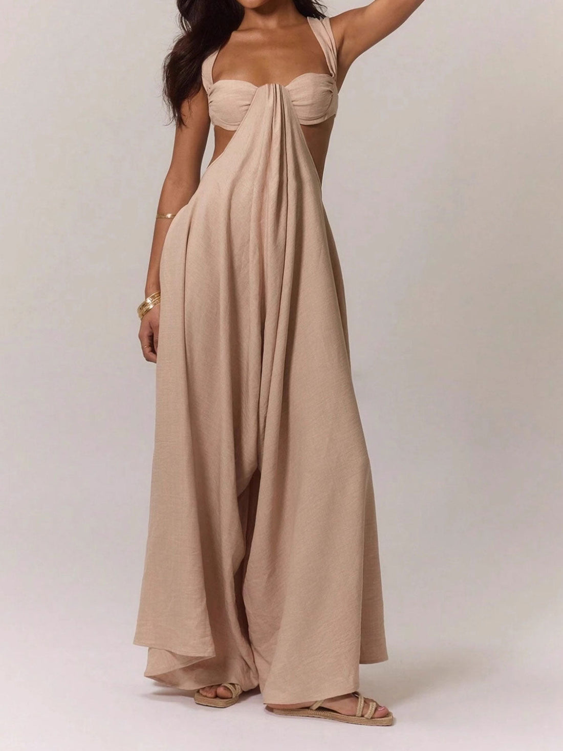 Woman wearing a beige linen blend jumpsuit with a strappy bralette top and wide legs, front view