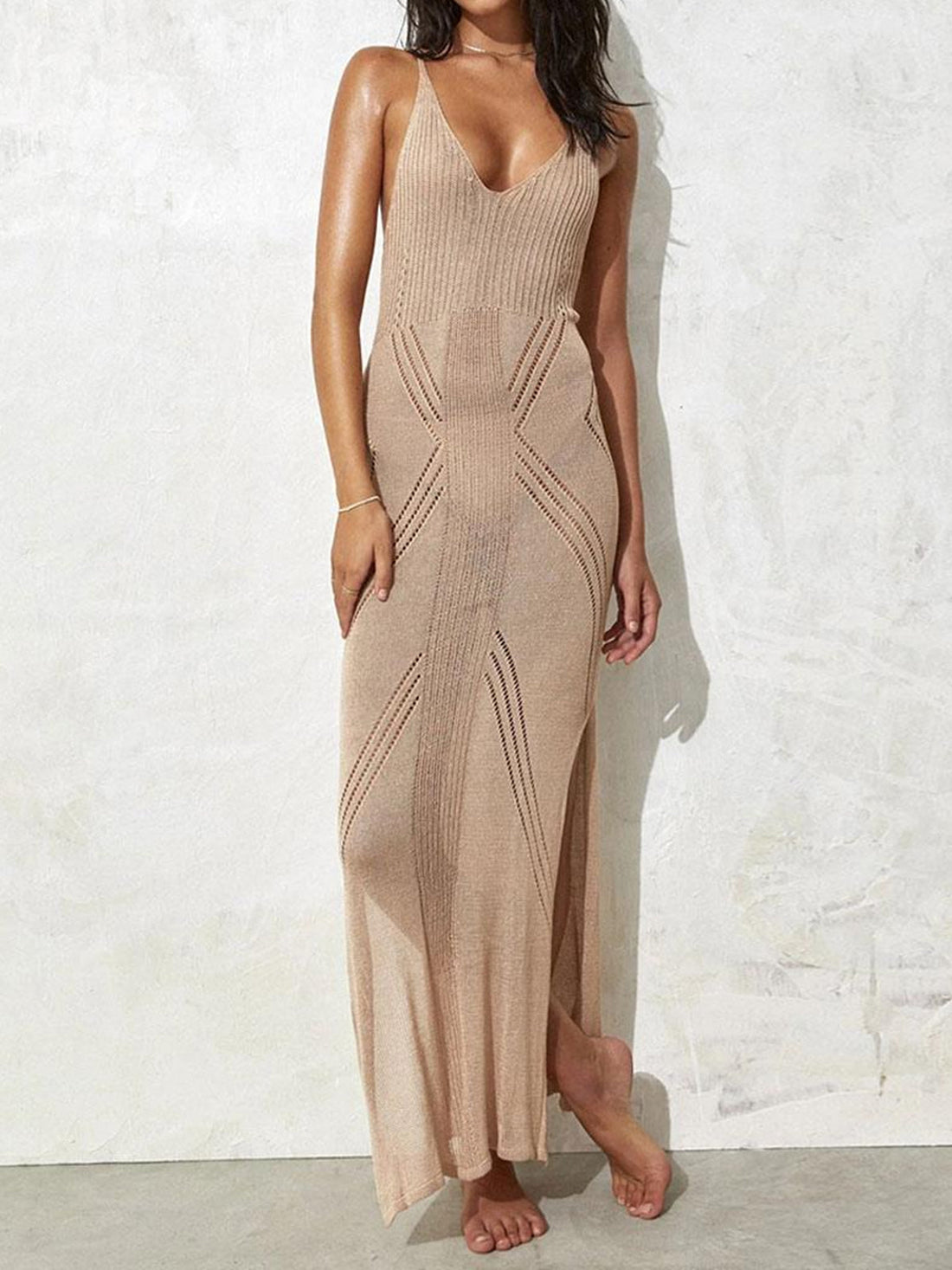 woman wearing a beige sheer knit maxi dress with geometric cut-outs and a high side slit