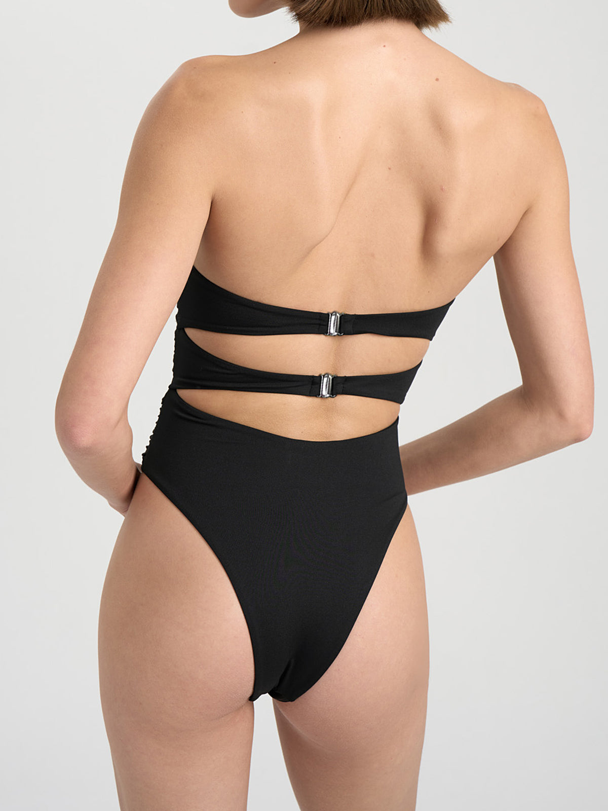 Front view of a model wearing a black one-piece swimsuit with floral accents