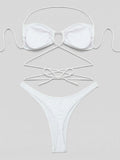 Flat lay of a white bikini set with halter top and high-cut bottoms showing tie detail