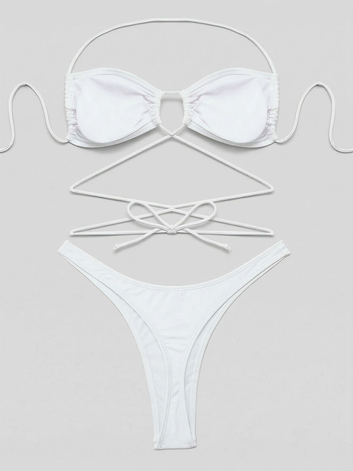Flat lay of a white bikini set with halter top and high-cut bottoms showing tie detail