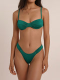 Woman wearing a deep green ruched bikini set with underwire bust support and adjustable straps.
