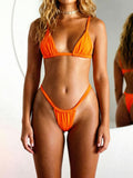 Woman wearing an orange triangle bikini with adjustable straps and a ruched low-rise bottom indoors.