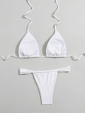 Back view of a white triangle bikini top and ruched thong bottoms laid flat