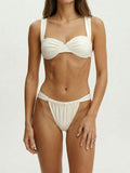 Woman wearing a white bikini set with underwire bust support and ruched detailing