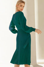Back view of a green long-sleeved knit dress with a full pleated skirt