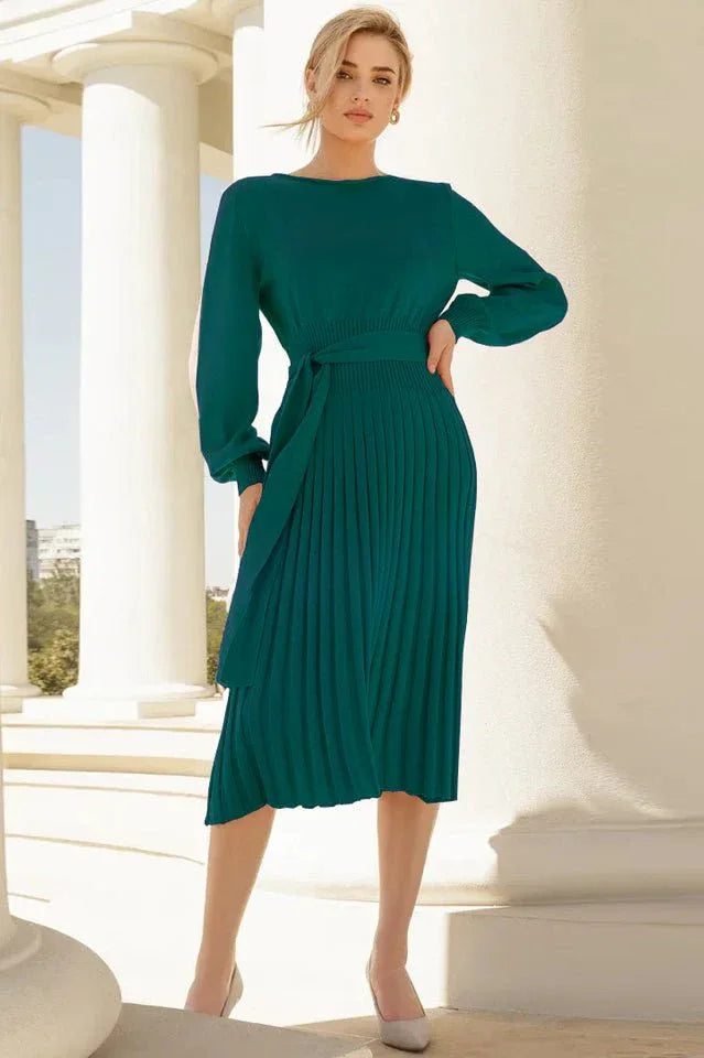 Woman wearing a long-sleeved green knit dress with a belted waist and pleated skirt Main image