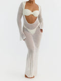 Woman wearing a white sheer knit maxi dress with long sleeves and a scoop neckline.