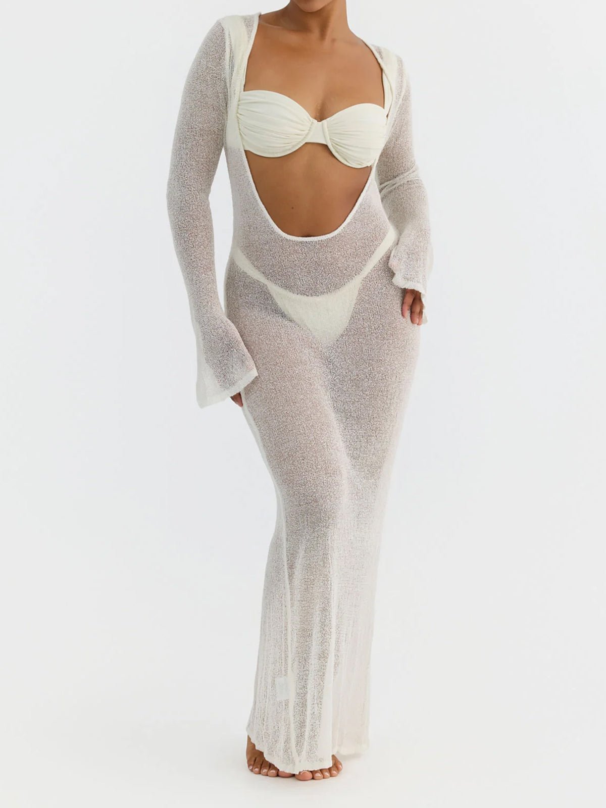 Woman wearing a white sheer knit maxi dress with long sleeves and a scoop neckline.