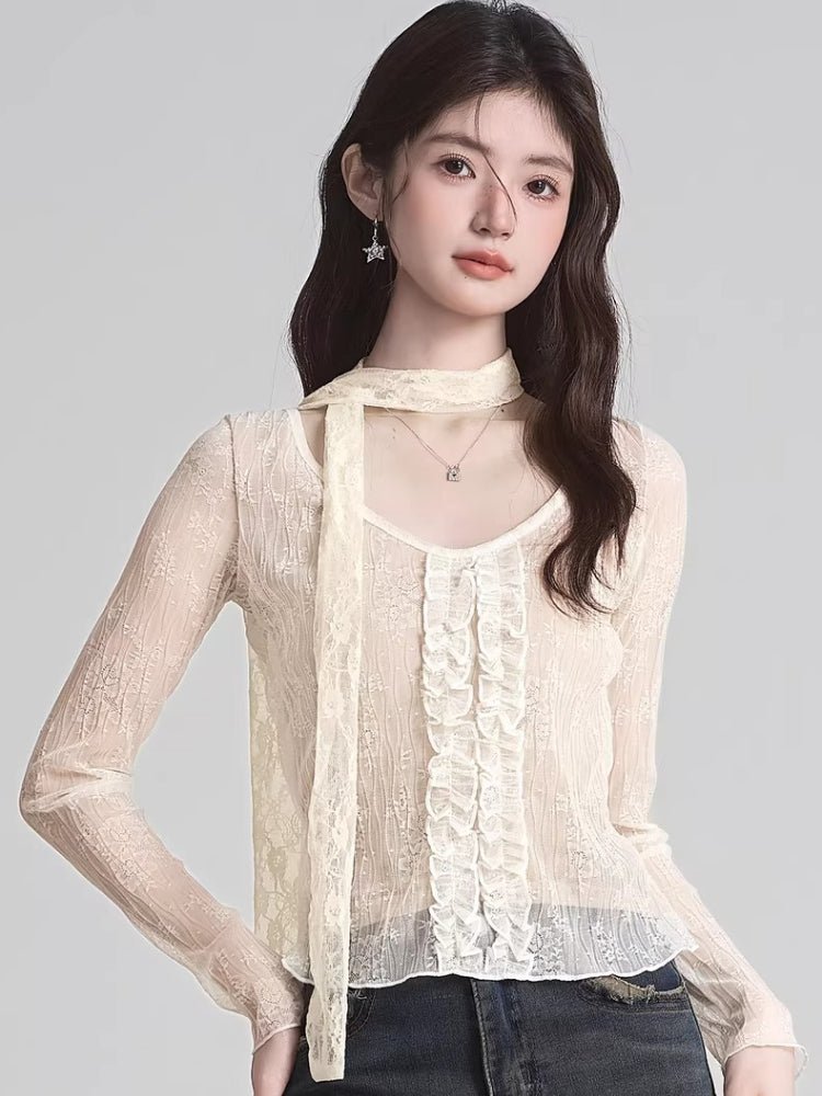 Woman wearing a cream lace long-sleeve top with ruffle front and neck scarf