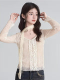 Woman posing in a cream lace long-sleeve top, showing the scarf detail
