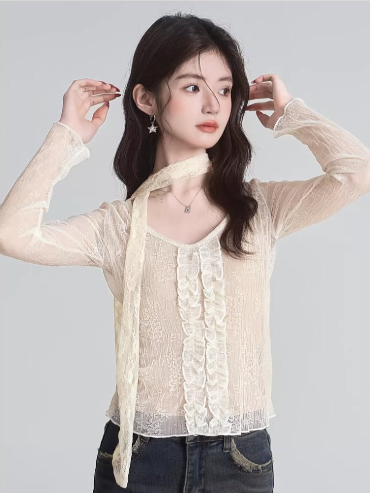 Woman posing in a cream lace long-sleeve top, showing the scarf detail