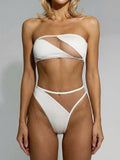 Woman wearing a white strapless bikini with cut-out details and sheer panels