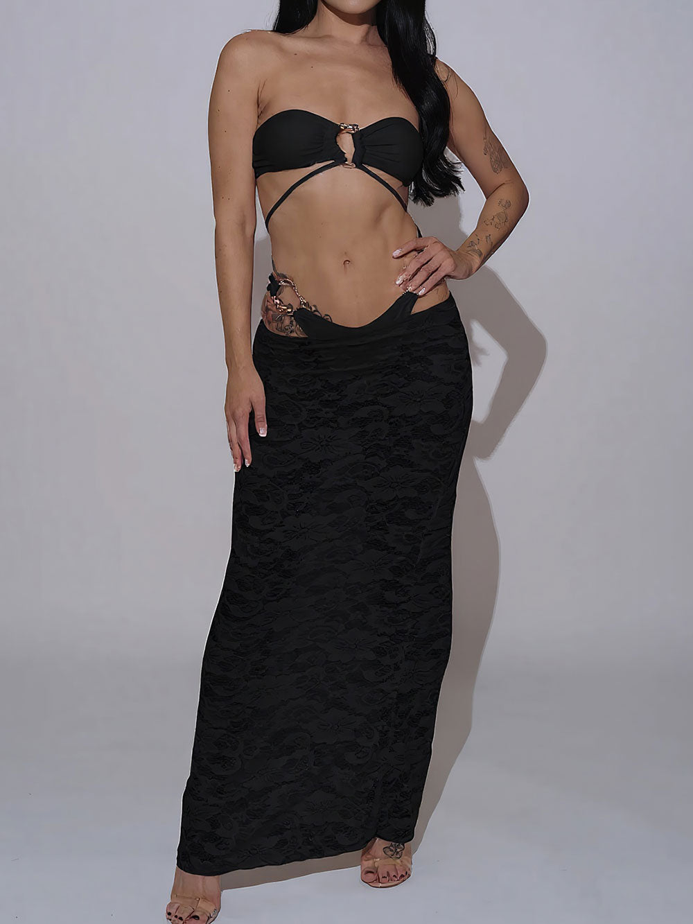 Woman wearing a white strapless bikini and a white lace maxi skirt