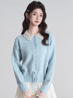 Woman wearing a light blue knit cardigan with a white lace collar and drawstring waist.