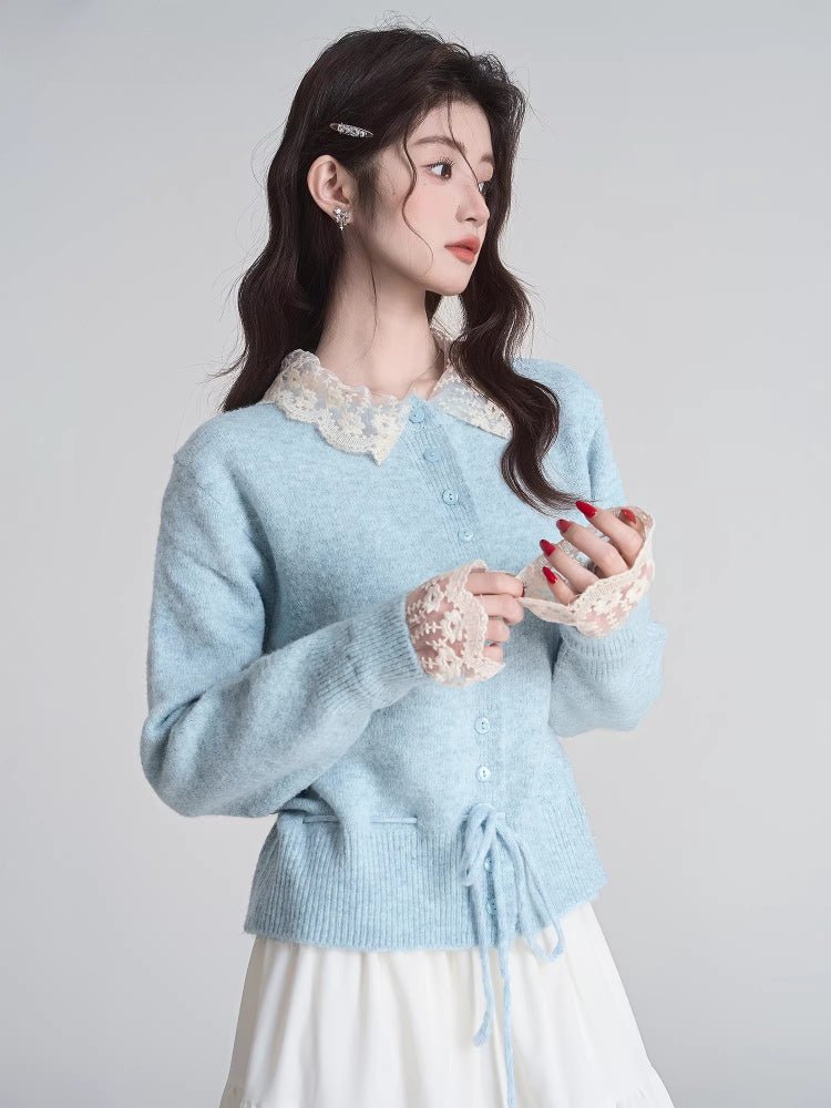 Woman adjusting the lace cuffs of her light blue knit cardigan.