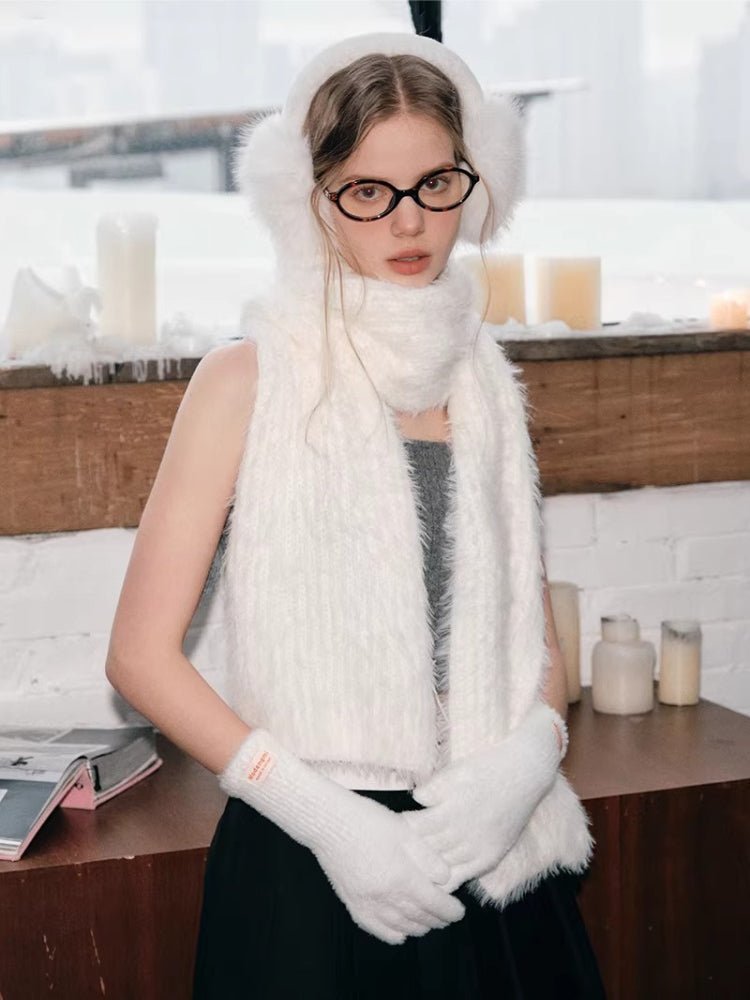 Woman wearing a white fuzzy scarf, earmuffs, and gloves