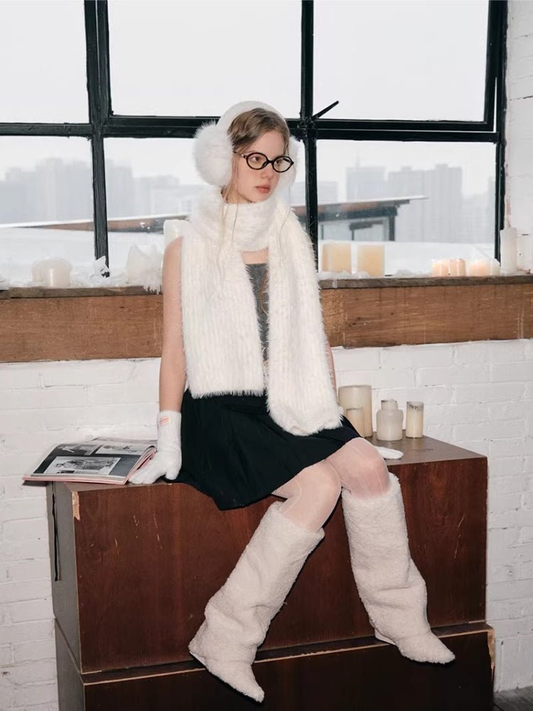 Woman sitting and modeling white winter accessories with a pleated skirt
