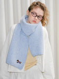 Model styled with a light blue scarf showcasing a playful dachshund embroidery.