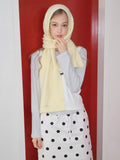 Woman wearing a pale yellow knit scarf as a head covering and around her neck.