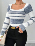 Close-up of a woman wearing a blue and white striped fuzzy knit top, highlighting the fabric texture and neckline.