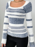 Front view of a woman in a blue and white striped fuzzy knit top with a scoop neck.