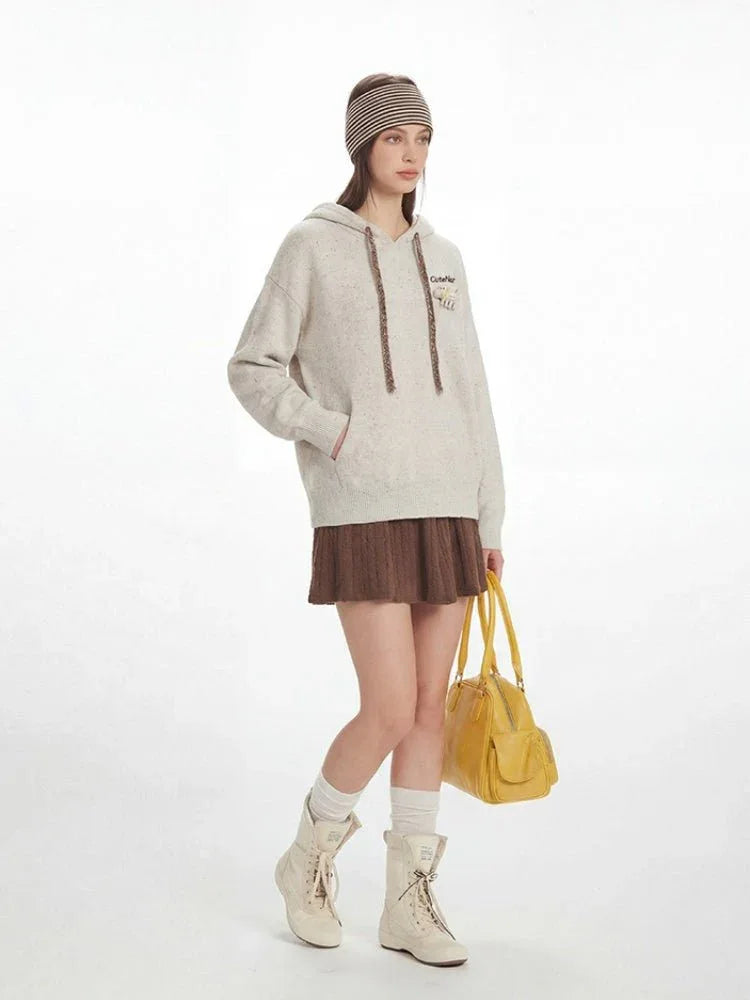 Side profile of a model in a casual outfit, holding a yellow handbag.