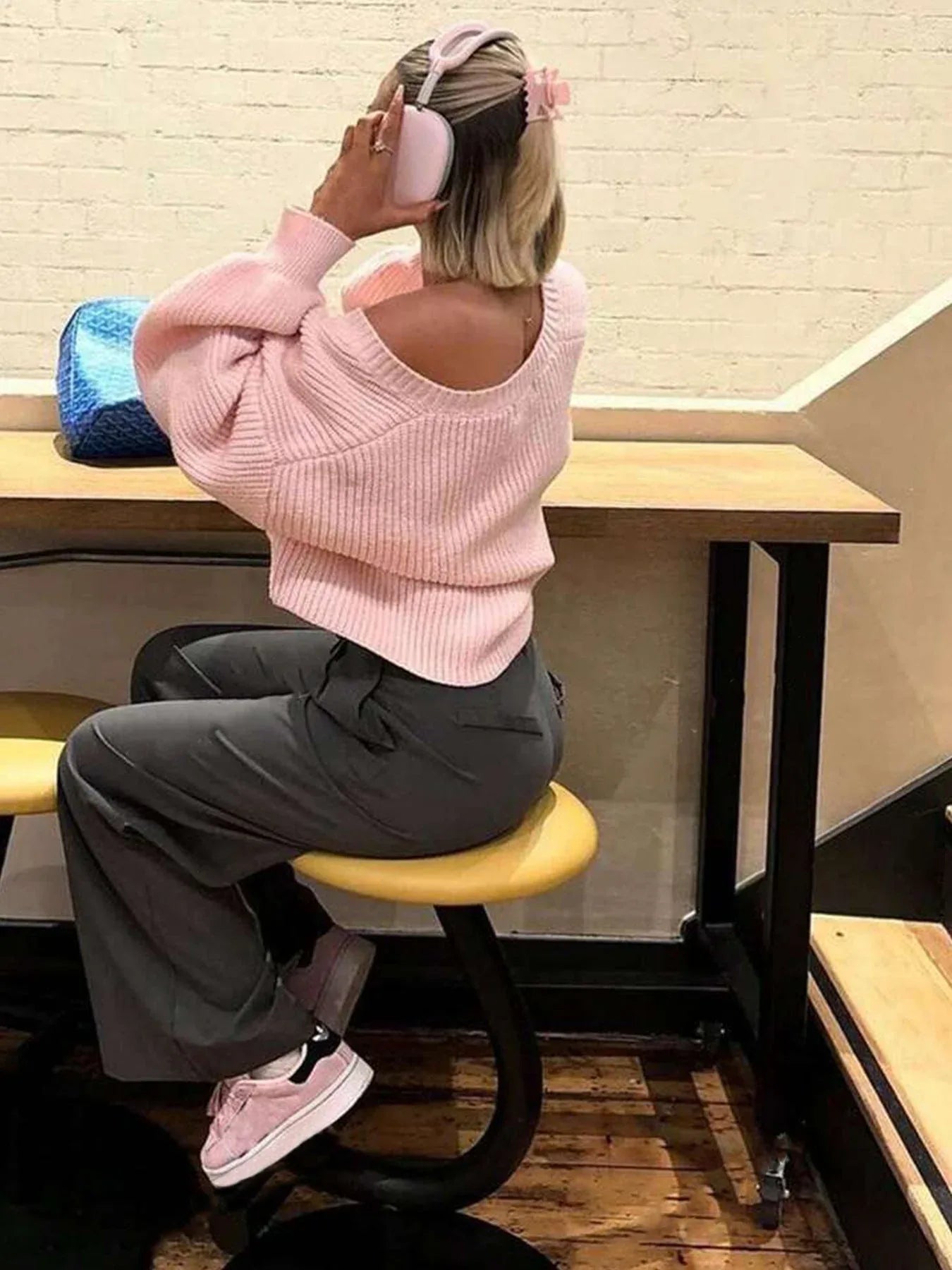 Rear view of a woman wearing a pink knit cardigan.