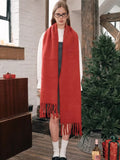 Full-body view of a woman wearing a long red scarf with fringe.
