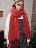 Close-up of a woman's face and shoulders wearing a red scarf.