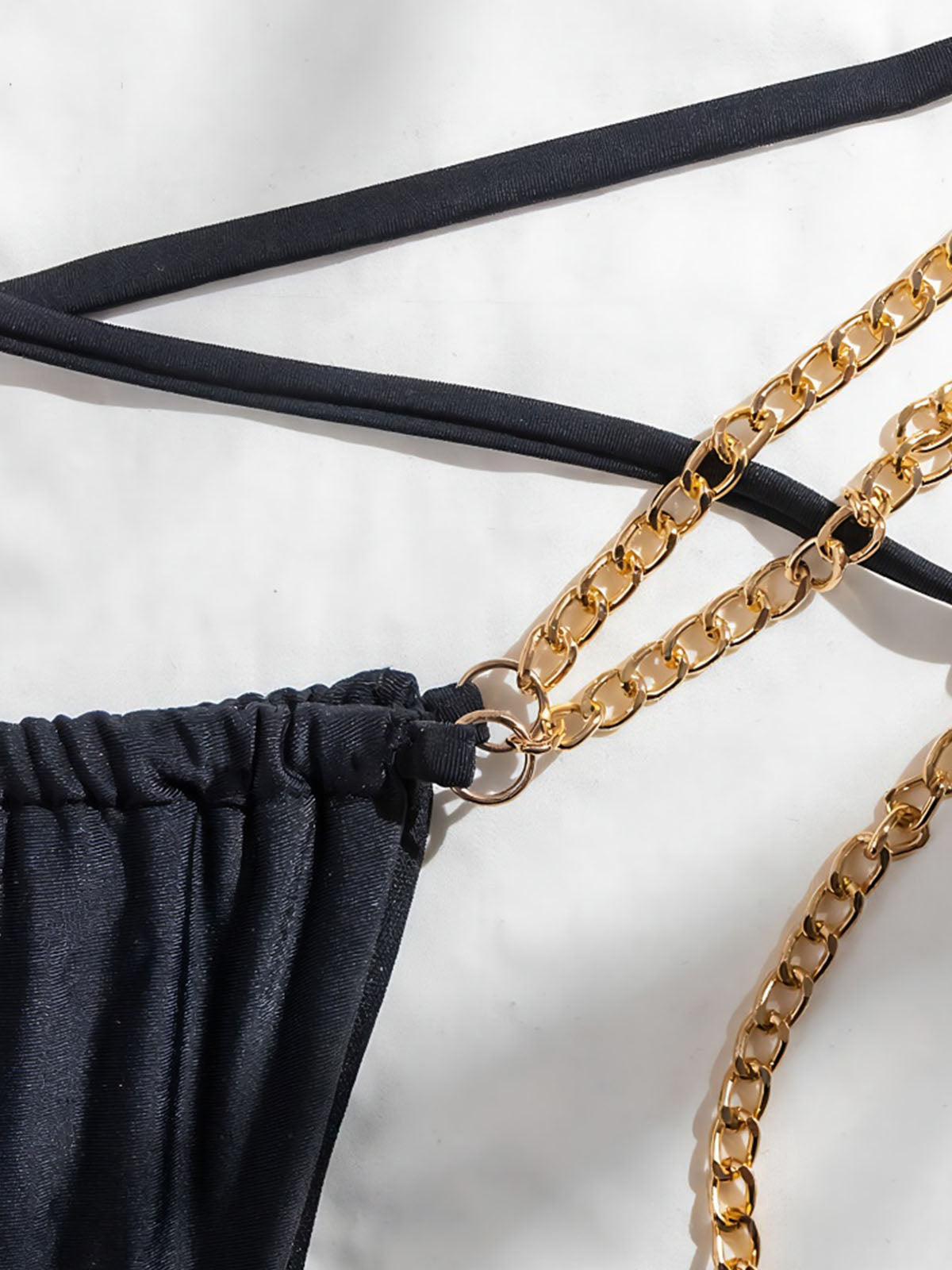 Close-up of gold chain detail on bikini bottom