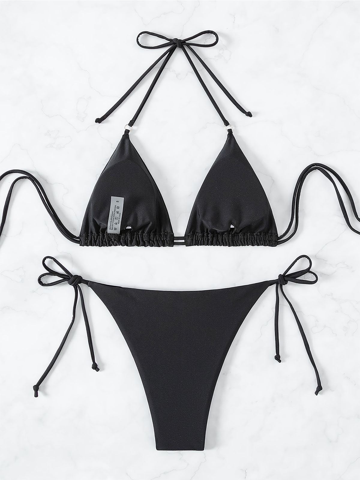 Flat lay of the reverse side of a black embellished triangle bikini set