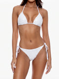 Woman wearing a white sequined halter bikini with tie-side bottoms
