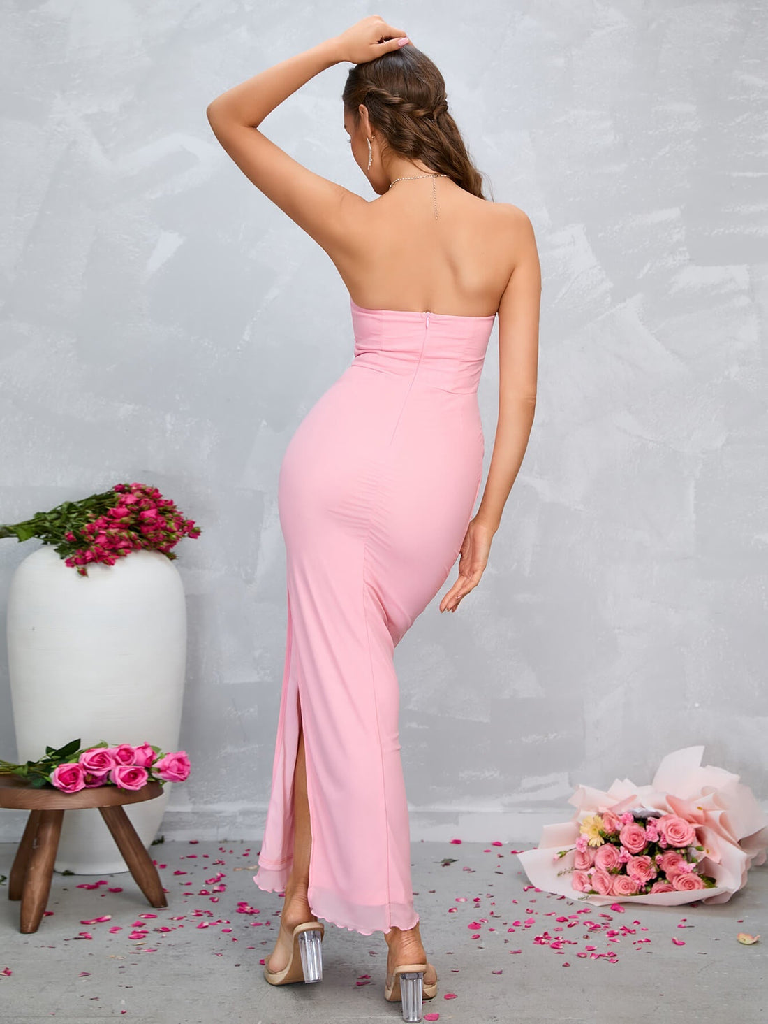 Woman in a pink strapless ruched maxi dress with a high slit