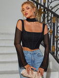 Woman wearing a black mesh long sleeve crop top with a square neckline and choker detail.
