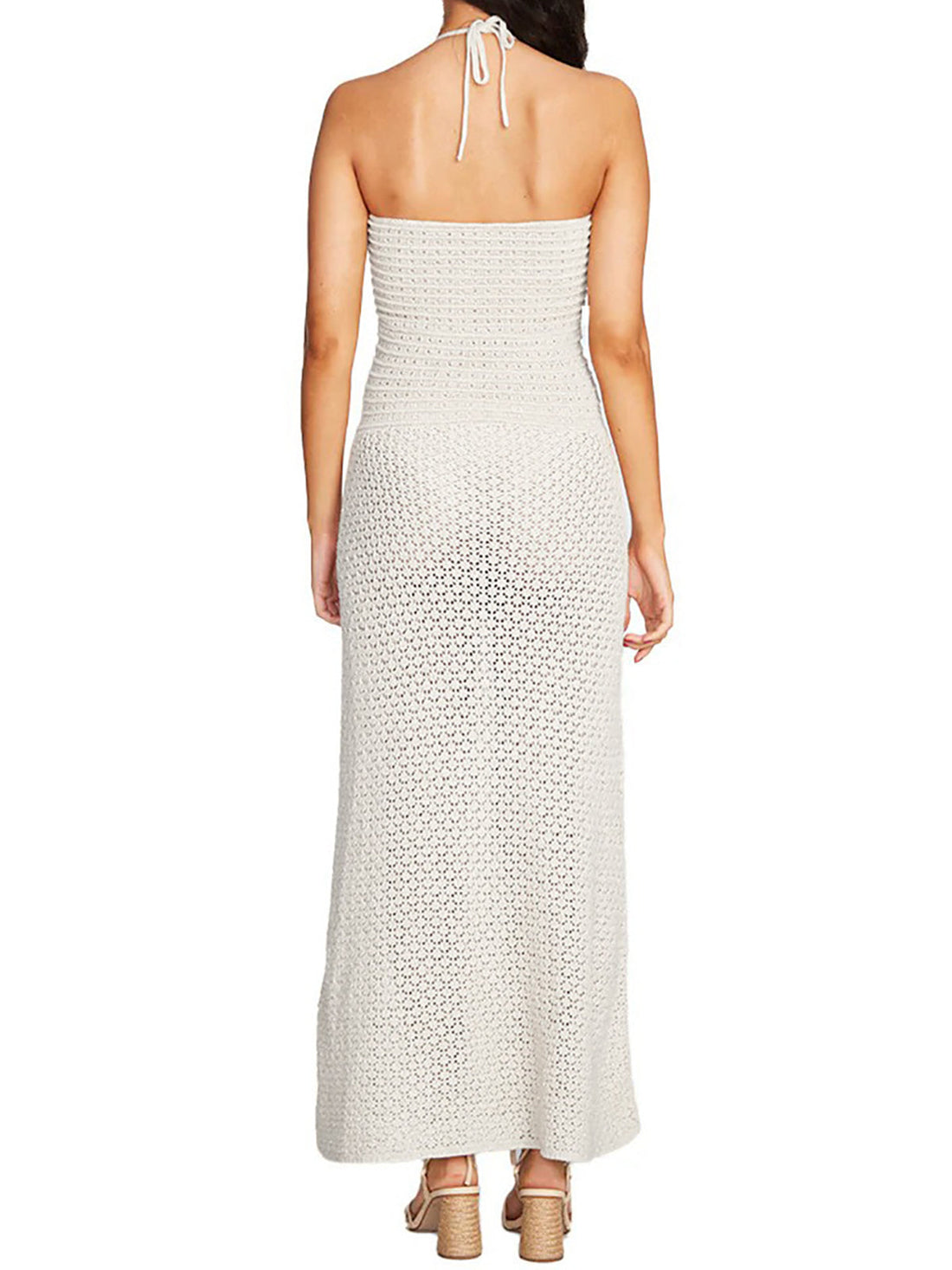Woman wearing a white crochet knit strapless maxi dress with a cutout and tie detail at the bust, back view