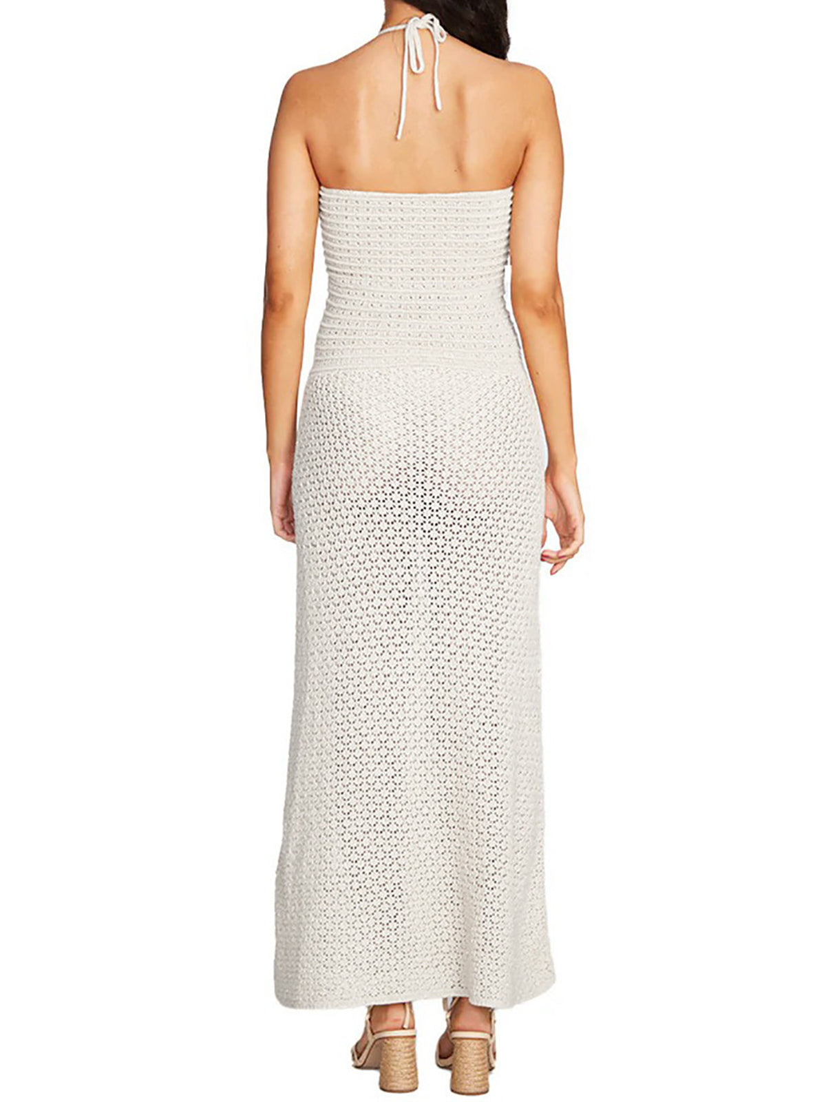 Woman wearing a white crochet knit strapless maxi dress with a cutout and tie detail at the bust, back view