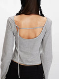 Rear view showing the open back detail of a striped long-sleeve cropped top