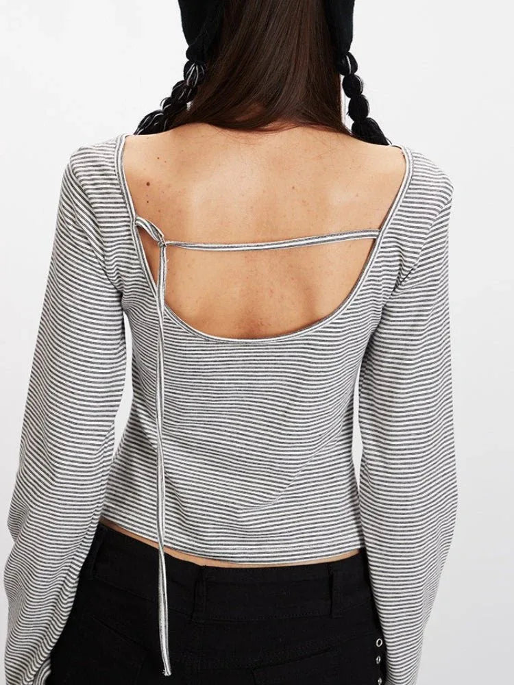 Rear view showing the open back detail of a striped long-sleeve cropped top