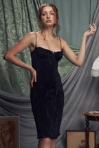 Close-up of a woman in a black ruched dress with a scalloped neckline.