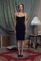 Full length studio shot of a woman in a black ruched dress.