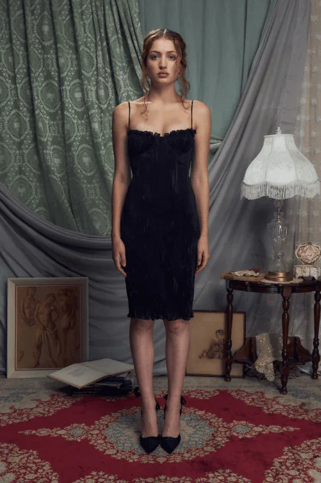 Full length studio shot of a woman in a black ruched dress.