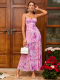 Woman wearing a pink floral print maxi dress with spaghetti straps and a sweetheart neckline.