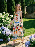 Woman wearing a white midi dress with a tropical print, walking in a garden with hydrangeas.