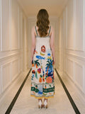 Back view of a woman wearing a white midi dress with a tropical print, standing in a hallway.
