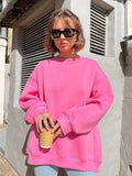 Close-up of a woman in a pink oversized sweatshirt.