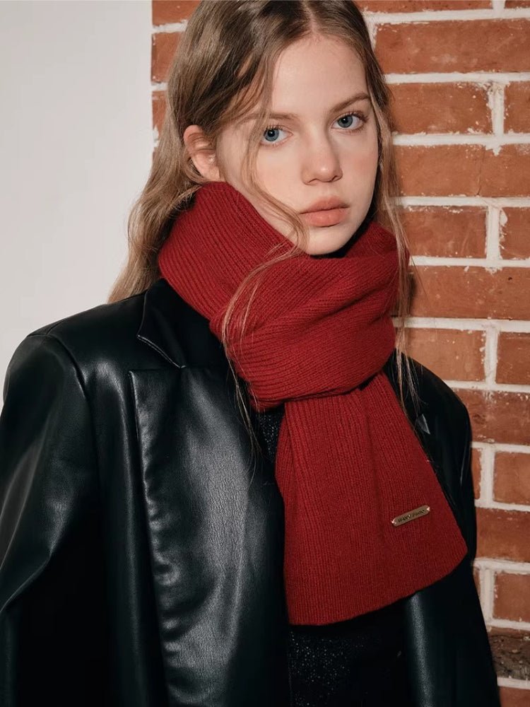 Model styled with a red knit scarf wrapped around her neck.