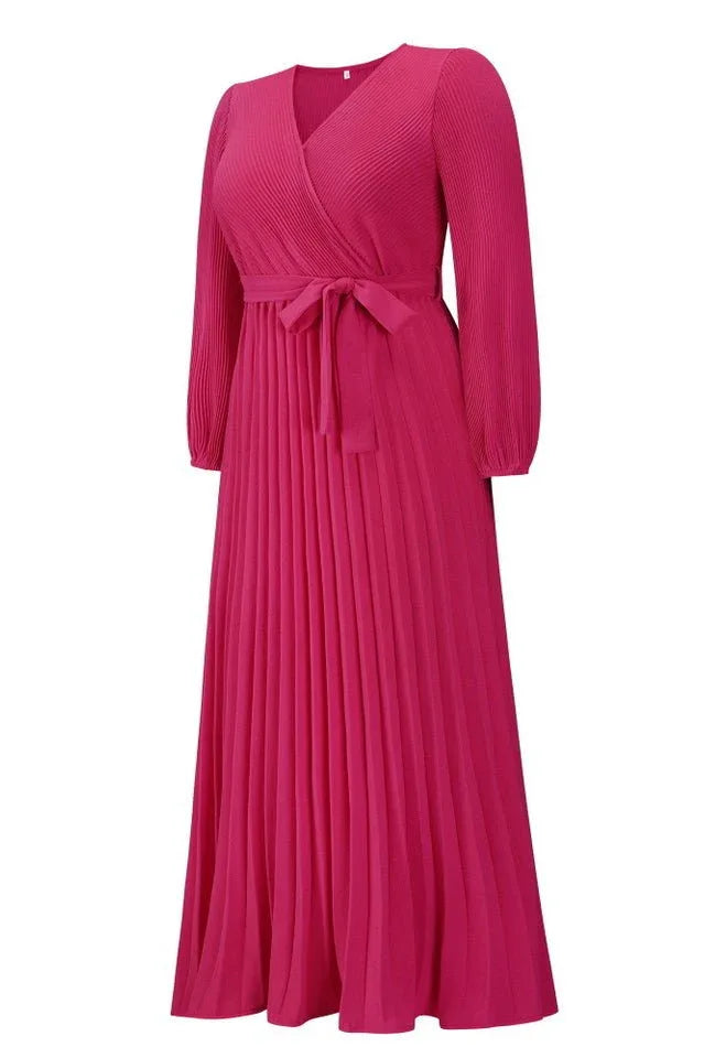 Side view of a pink pleated maxi dress with a v-neck and long sleeves.