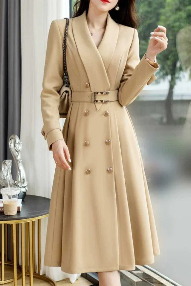 woman wearing a beige double-breasted midi coat dress with a notched lapel collar and a belted waist