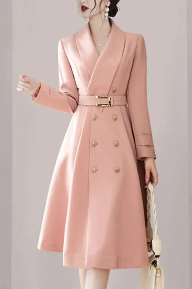 woman wearing a pink double-breasted midi coat dress with a notched lapel collar and a belted waist